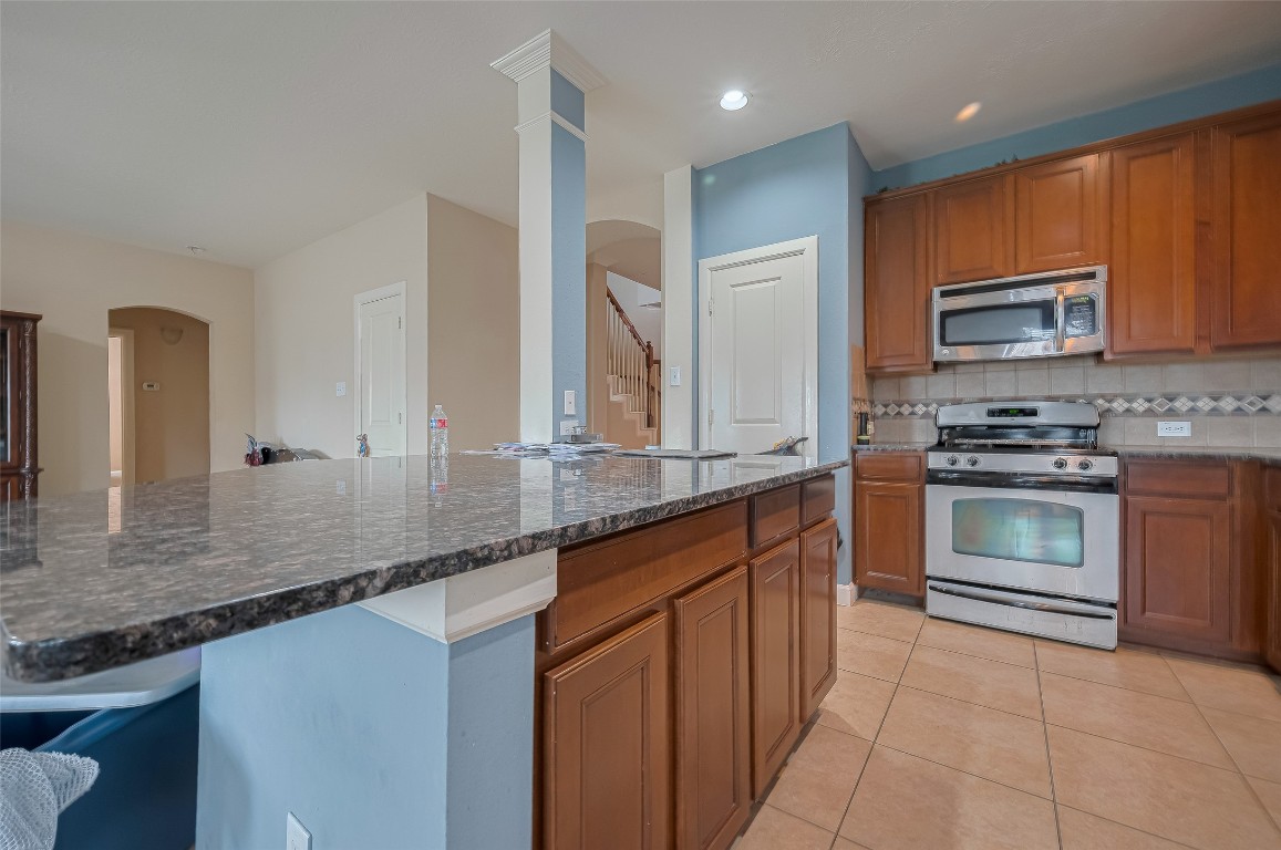 1703 Macclesby Lane Houston, TX 77049 - Photo 15 of 41 a kitchen with stainless steel appliances granite countertop a stove a sink and a microwave