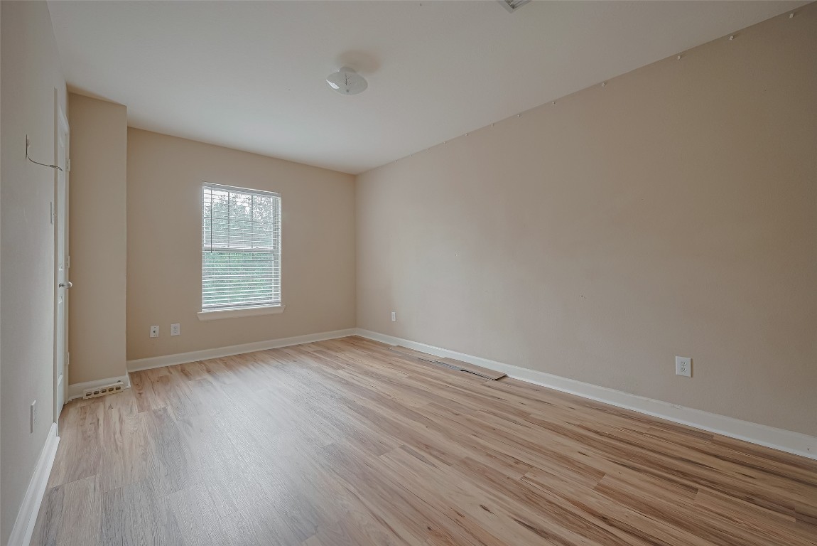 1703 Macclesby Lane Houston, TX 77049 - Photo 28 of 41 a view of an empty room with wooden floor and a window
