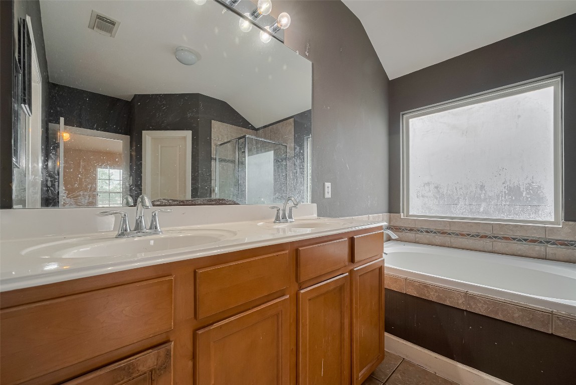 1703 Macclesby Lane Houston, TX 77049 - Photo 35 of 41 a bathroom with a granite countertop sink mirror and a bathtub