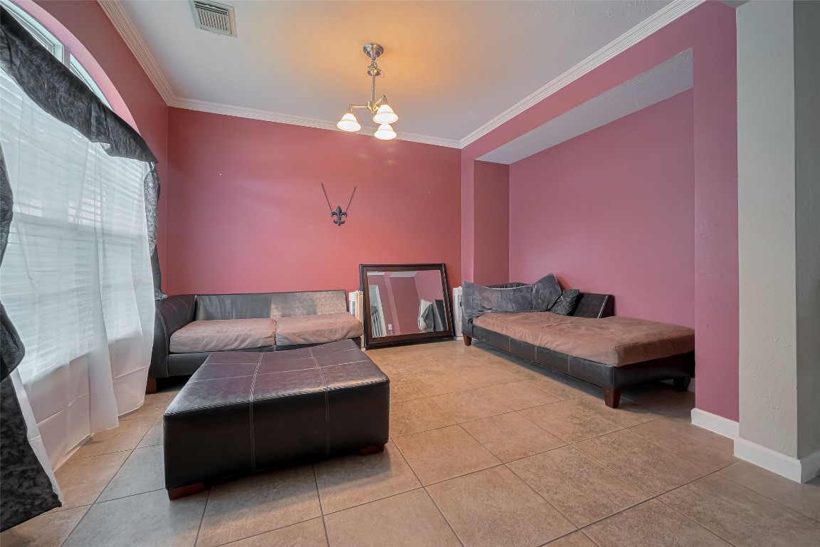 1703 Macclesby Lane Houston, TX 77049 - Photo 5 of 41 a bedroom with furniture and a chandelier