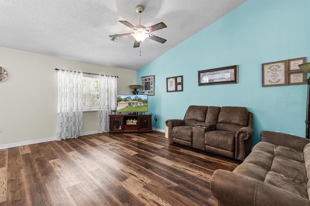 16038 Malden Road Weeki Wachee, FL 34614 - Photo 11 of 40 a living room with furniture and a chandelier