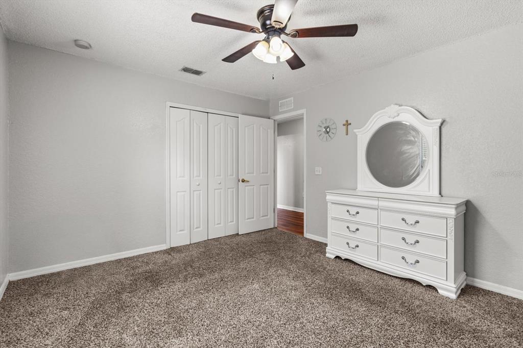 16038 Malden Road Weeki Wachee, FL 34614 - Photo 19 of 40 a bedroom with a dresser and a chandelier