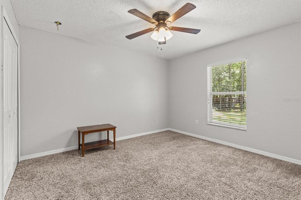 16038 Malden Road Weeki Wachee, FL 34614 - Photo 24 of 40 a view of an empty room with a window and a ceiling fan