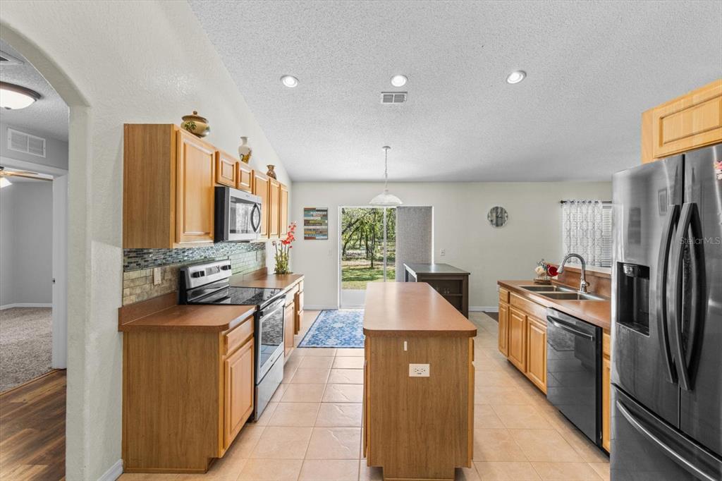 16038 Malden Road Weeki Wachee, FL 34614 - Photo 5 of 40 a kitchen with stainless steel appliances granite countertop a sink stove and refrigerator