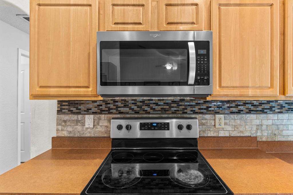 16038 Malden Road Weeki Wachee, FL 34614 - Photo 7 of 40 a kitchen with a stove and a microwave