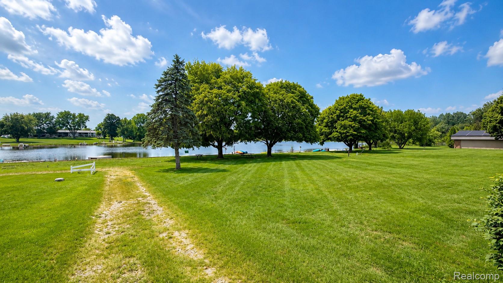 26945 Milford Road, Unit 34 New Hudson, MI 48165 - Photo 4 of 16 Expansive grass lawn with mature trees and waterfront access