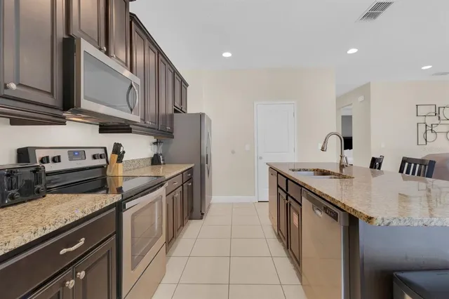 a kitchen with stainless steel appliances granite countertop a sink stove and cabinets