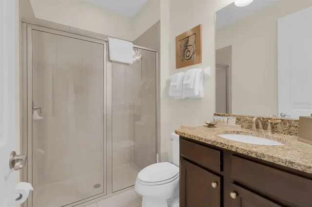 a bathroom with a granite countertop sink toilet and shower