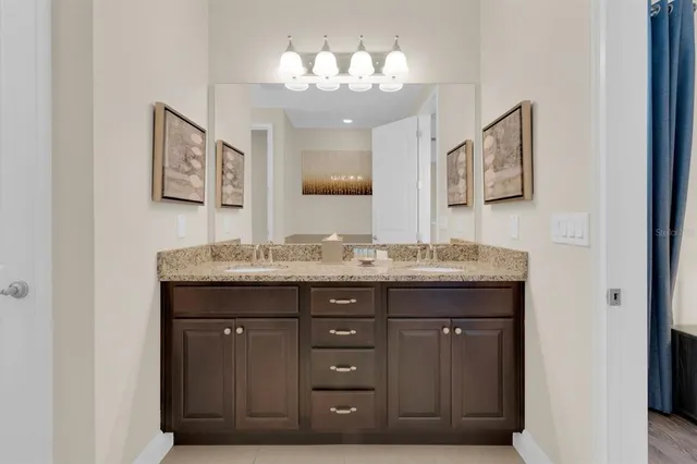 a bathroom with a granite countertop sink a mirror and a vanity