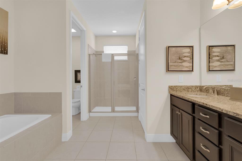 7403 Marker Avenue Kissimmee, FL 34747 - Photo 19 of 49 a bathroom with a granite countertop sink a toilet and shower