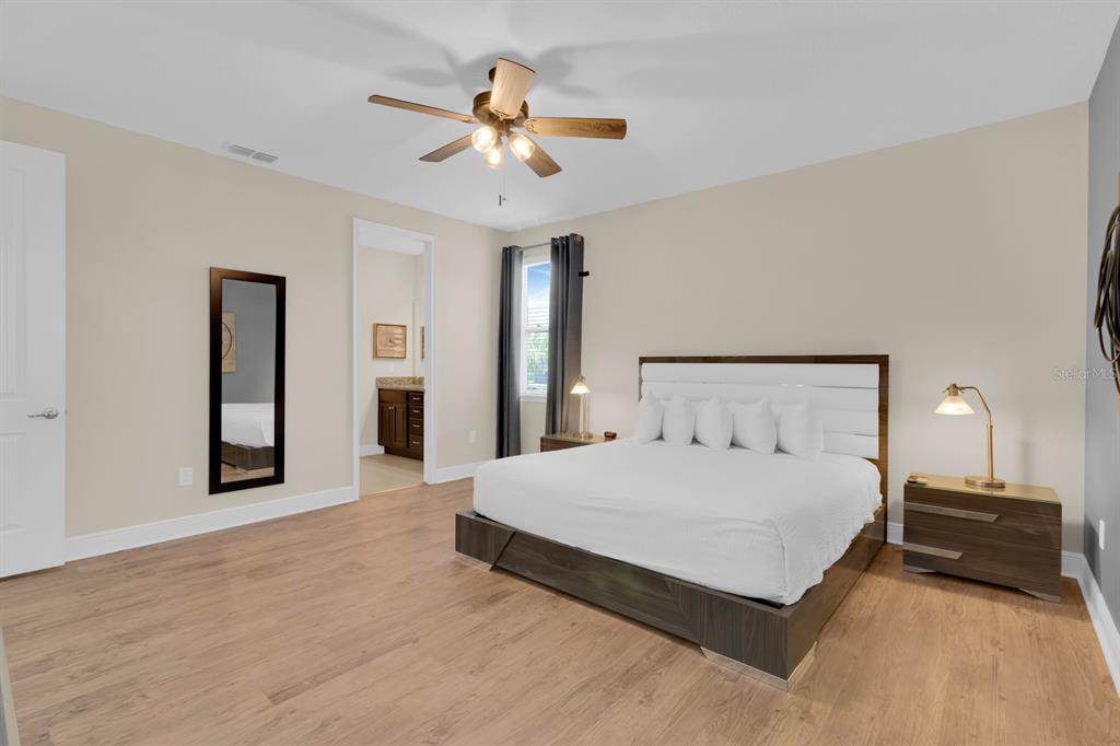 7403 Marker Avenue Kissimmee, FL 34747 - Photo 20 of 49 a bedroom with a large bed and a chandelier