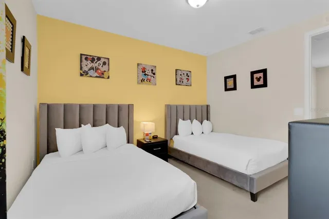 a bedroom with two beds and a night stand