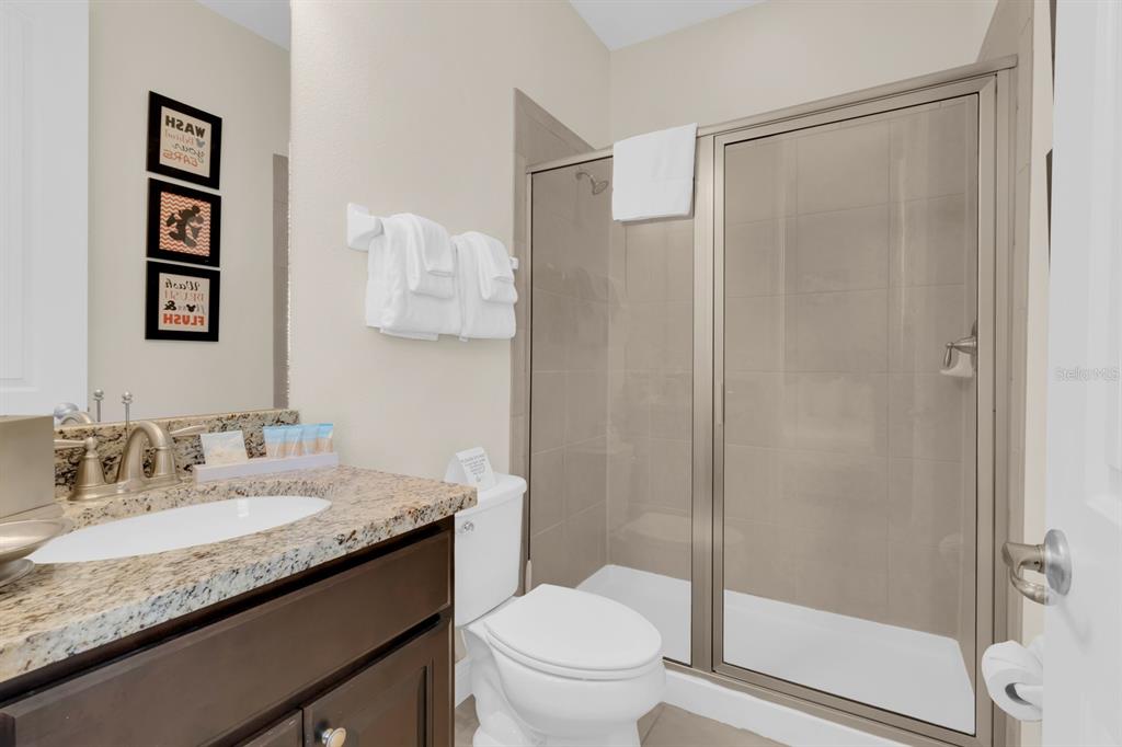 7403 Marker Avenue Kissimmee, FL 34747 - Photo 23 of 49 a bathroom with a granite countertop sink toilet and shower