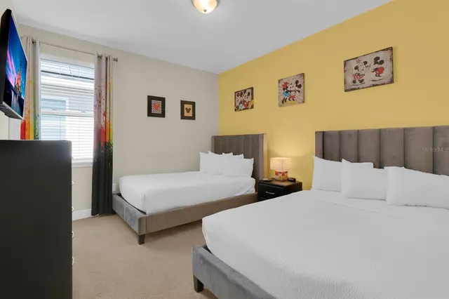 a bedroom with two beds and painting on the wall