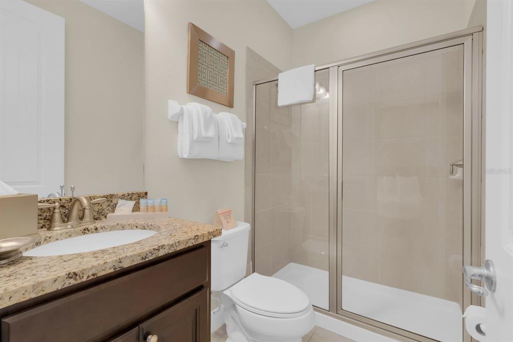 7403 Marker Avenue Kissimmee, FL 34747 - Photo 27 of 49 a bathroom with a granite countertop sink toilet and shower