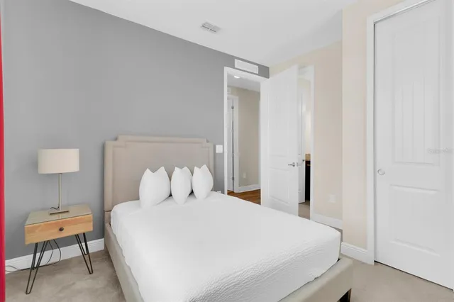 a bedroom with a bed and a flat tv screen on dresser