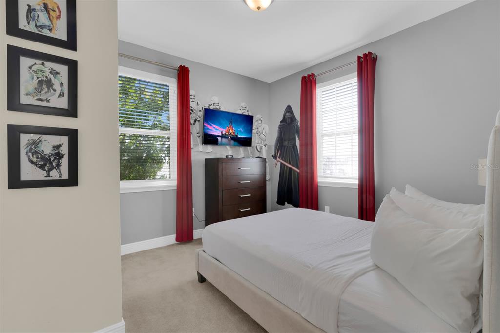 7403 Marker Avenue Kissimmee, FL 34747 - Photo 33 of 49 a bedroom with a bed and a flat tv screen on dresser