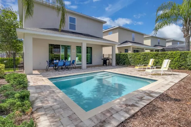 a view of a swimming pool with a patio and plants