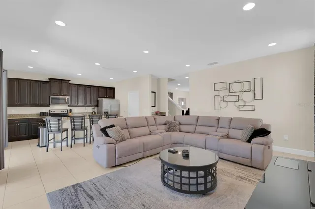 a living room with lots of furniture and kitchen view