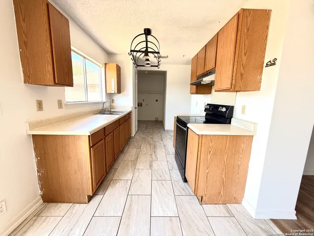 a kitchen with a sink cabinets and window