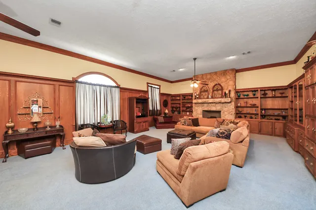 a living room with furniture a fireplace and a large window