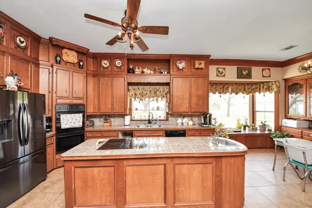 a kitchen with stainless steel appliances granite countertop a sink a stove and a refrigerator