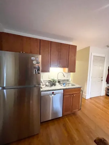 a kitchen with stainless steel appliances granite countertop a refrigerator a sink and a stove