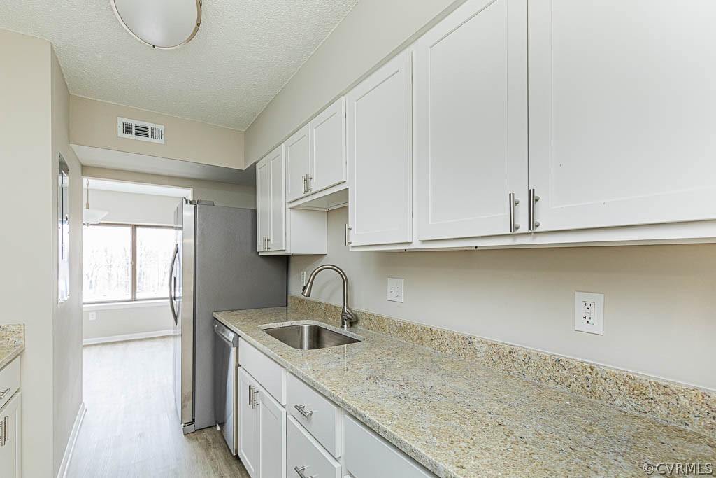 1511 Regency Woods Road, Unit 302 Henrico, VA 23238 - Photo 3 of 23 a kitchen with white cabinets a sink and dishwasher
