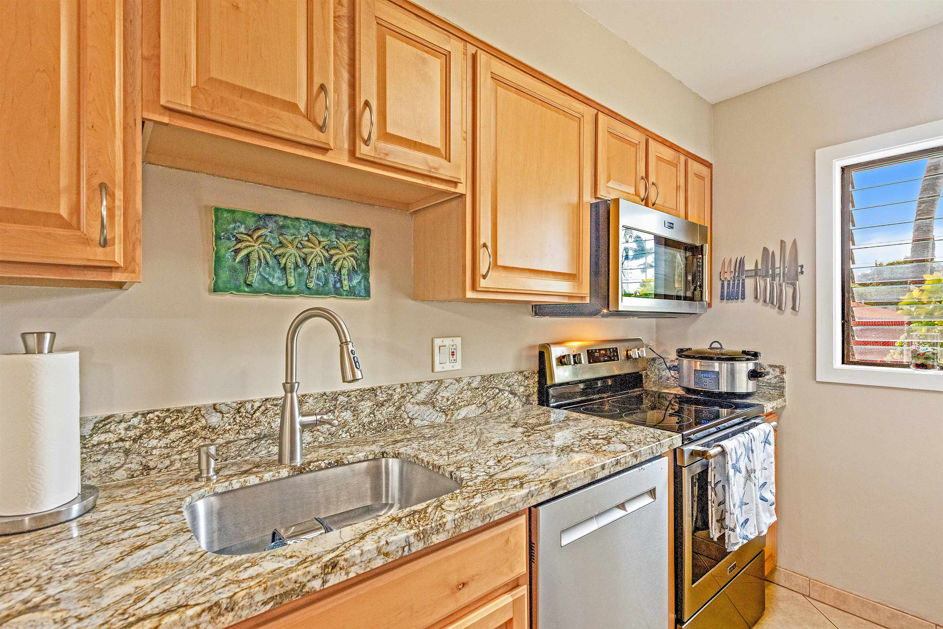 3788 Lower Honoapiilani Road, Unit A110 Lahaina, HI 96761 - Photo 11 of 35 a kitchen with stainless steel appliances granite countertop a sink stove and cabinets