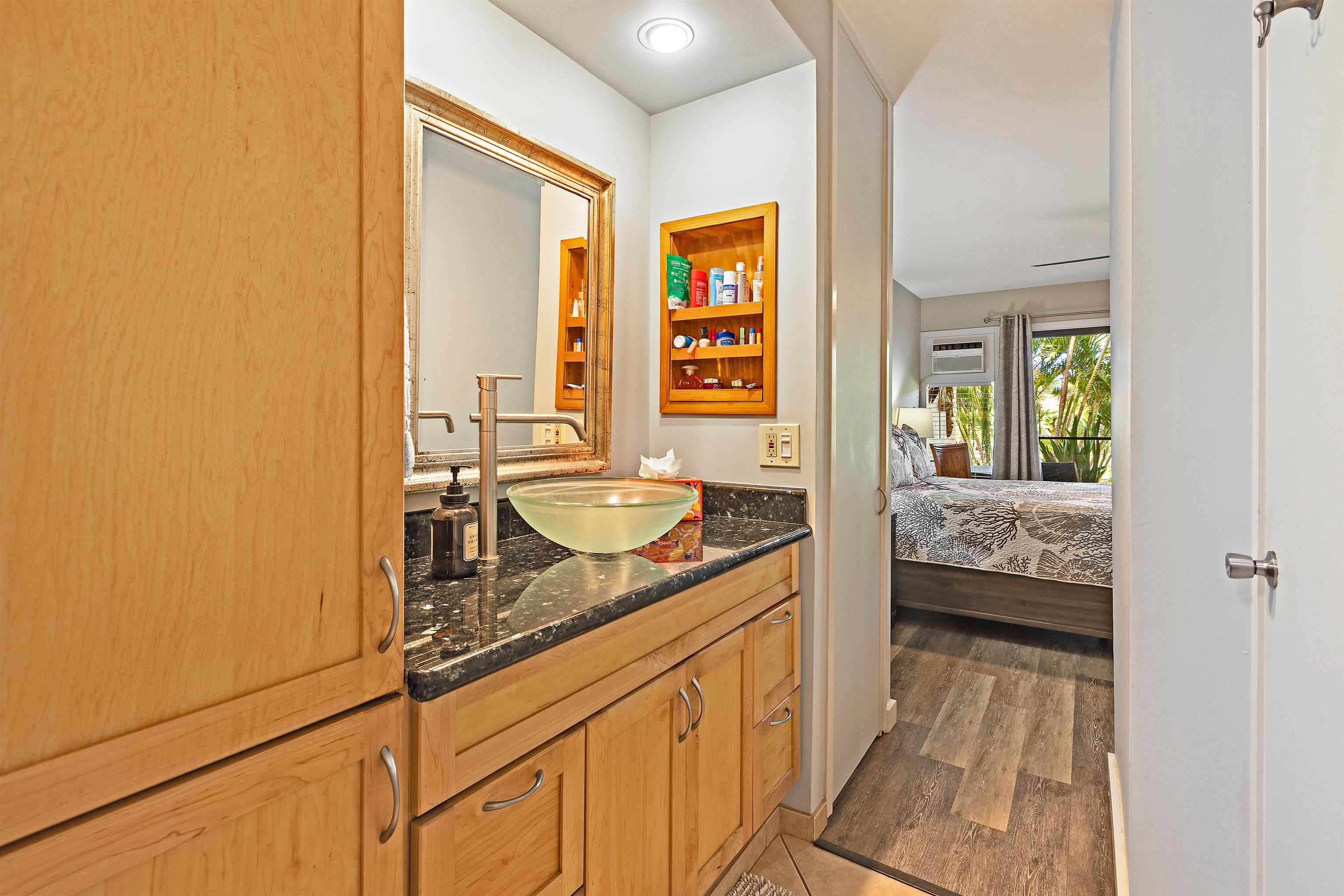 3788 Lower Honoapiilani Road, Unit A110 Lahaina, HI 96761 - Photo 22 of 35 a en suite bathroom with a granite countertop sink and a large mirror