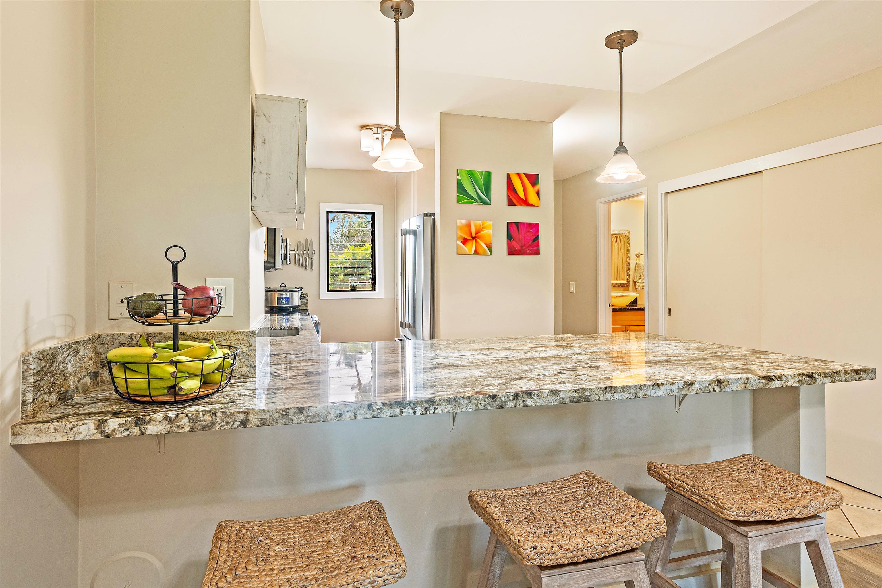 3788 Lower Honoapiilani Road, Unit A110 Lahaina, HI 96761 - Photo 6 of 35 a view of a kitchen and dining table with granite countertop chairs