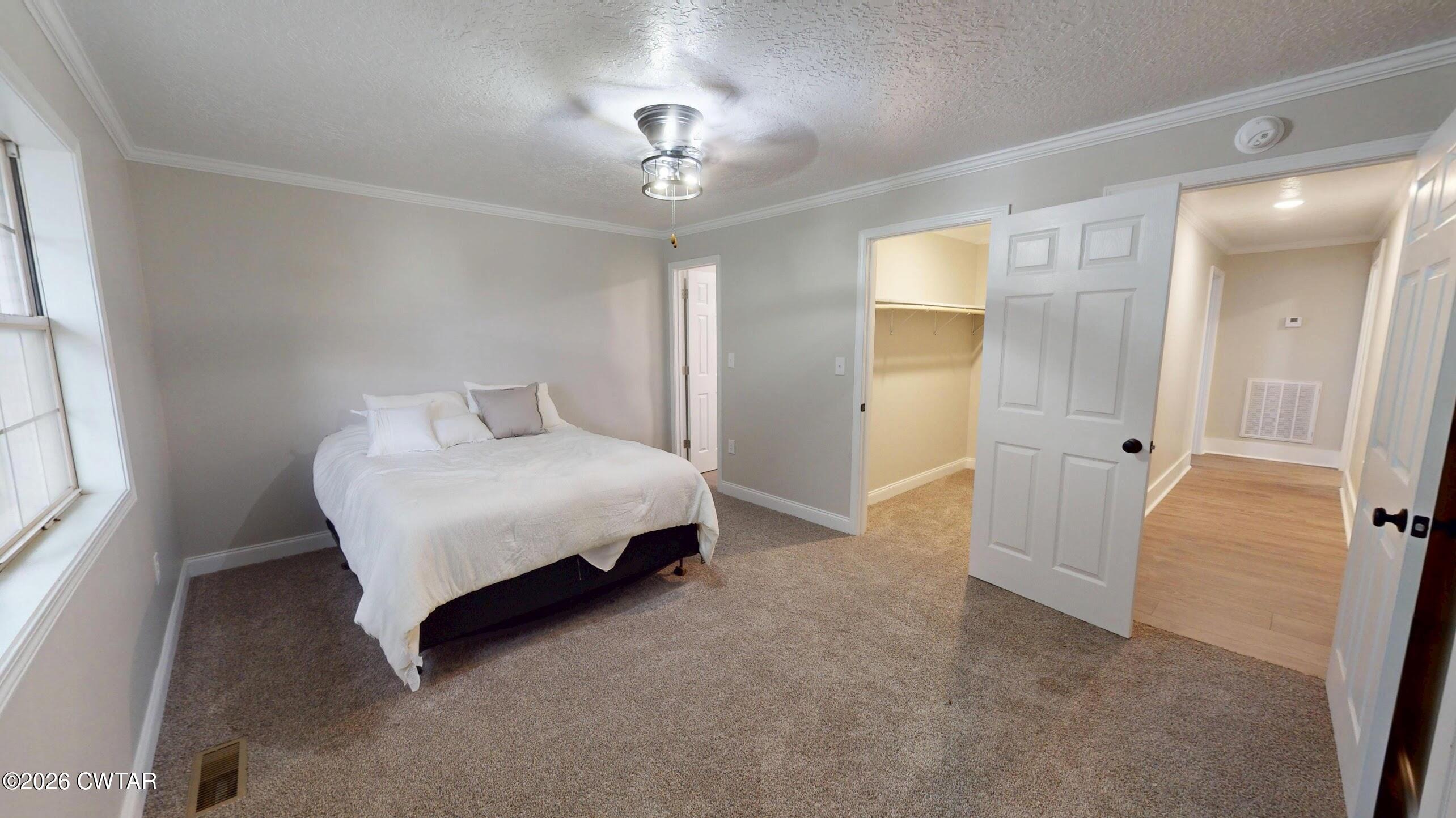 2800 Locust Grove Road Newbern, TN 38059 - Photo 34 of 46 a spacious bedroom with a bed and a chandelier