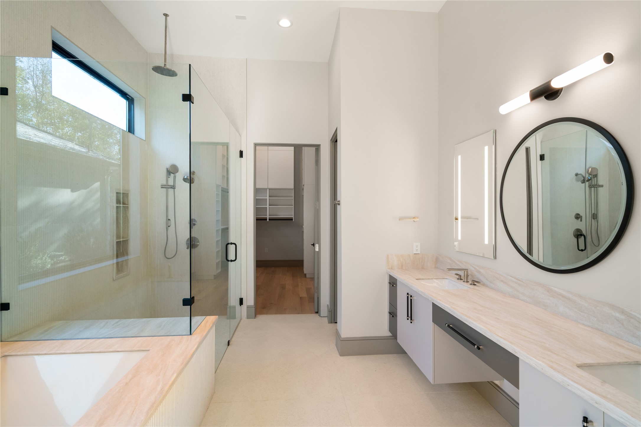 47 Pronghorn Place Spring, TX 77389 - Photo 21 of 48 This modern bathroom features a spacious glass-enclosed shower, a large soaking tub, dual sinks with a sleek vanity, and ample natural light, providing a luxurious and serene atmosphere.