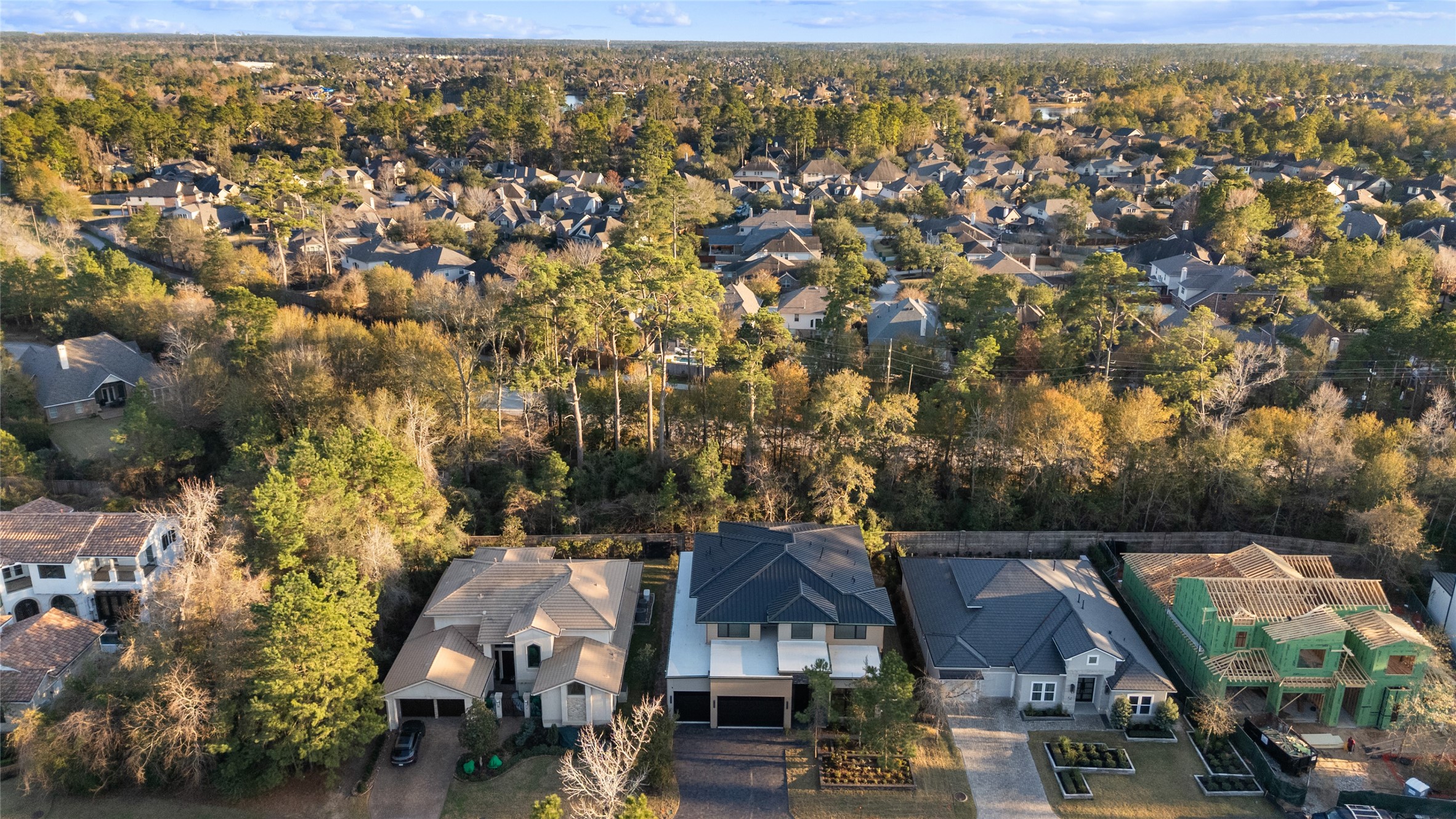 47 Pronghorn Place Spring, TX 77389 - Photo 4 of 48 This aerial photo showcases a suburban neighborhood with modern homes surrounded by lush greenery and a dense tree line. The area appears peaceful with well-maintained properties and a variety of architectural styles. It's an inviting setting for potential home buyers seeking a tranquil residential environment.