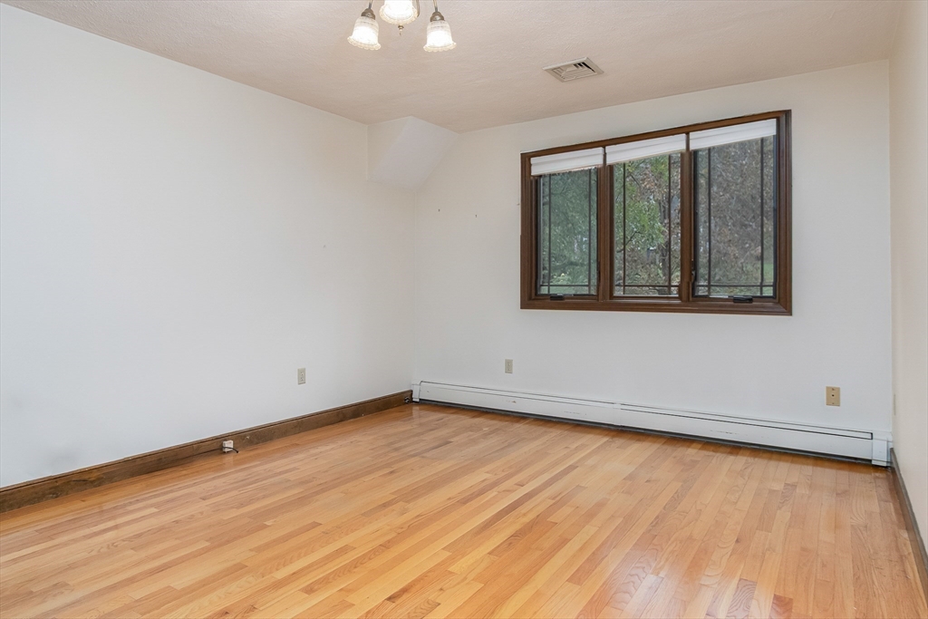 21 Saddle Lane Groton, MA 01450 - Photo 17 of 31 a view of an empty room with wooden floor and a window