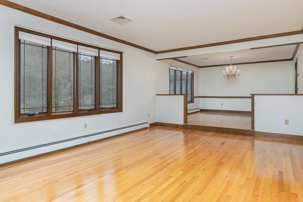 21 Saddle Lane Groton, MA 01450 - Photo 4 of 31 a view of an empty room with wooden floor and a window