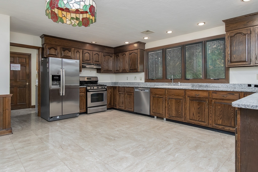 21 Saddle Lane Groton, MA 01450 - Photo 8 of 31 a large kitchen with stainless steel appliances granite countertop a stove refrigerator and a sink