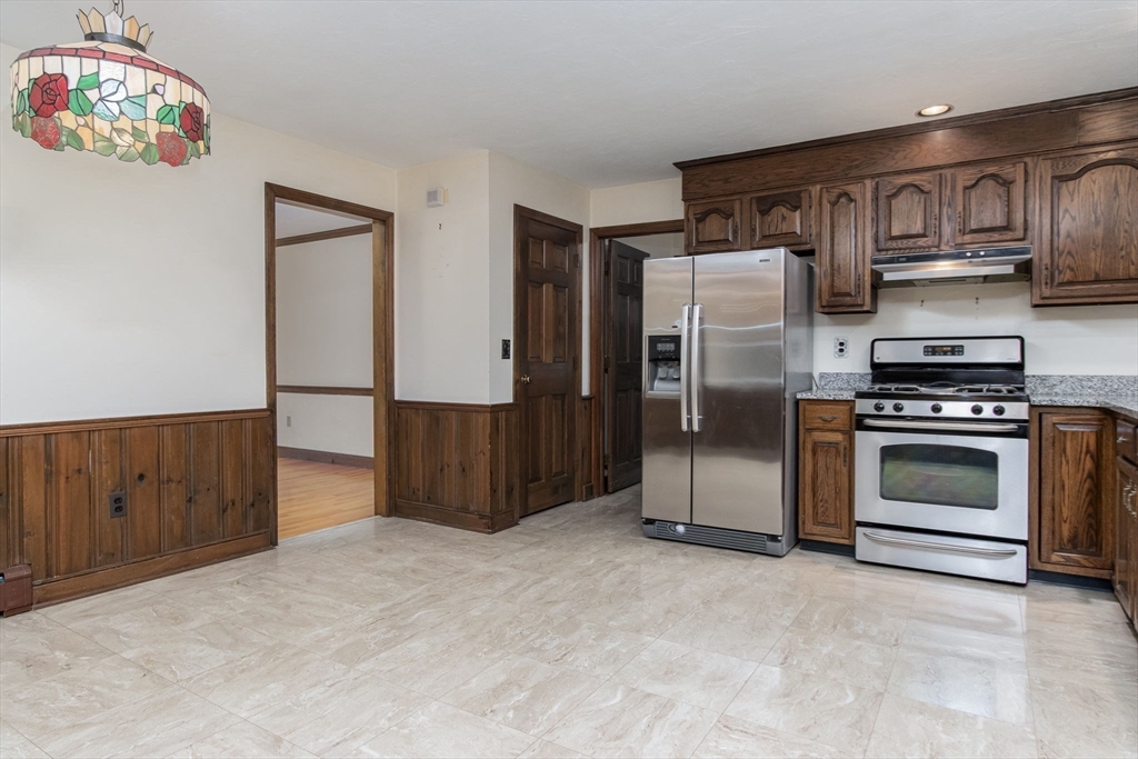 21 Saddle Lane Groton, MA 01450 - Photo 9 of 31 a kitchen with stainless steel appliances a stove a refrigerator and cabinets