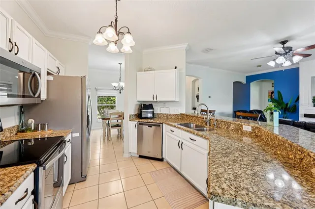 a large kitchen with stainless steel appliances granite countertop a sink dishwasher stove and refrigerator