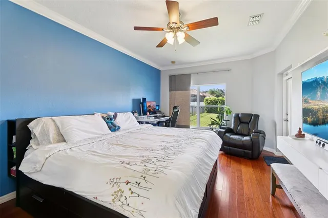 a bedroom with a bed a chandelier and a large window