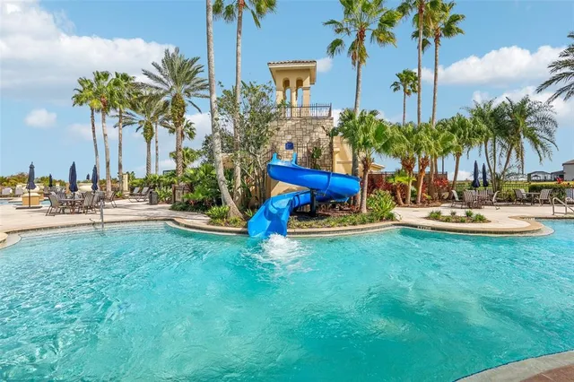 a row of palm trees sitting in a yard with swimming pool