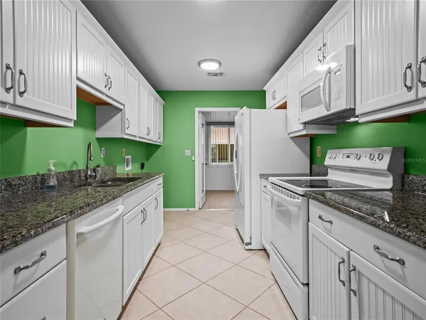 a kitchen with stainless steel appliances granite countertop a sink and a refrigerator