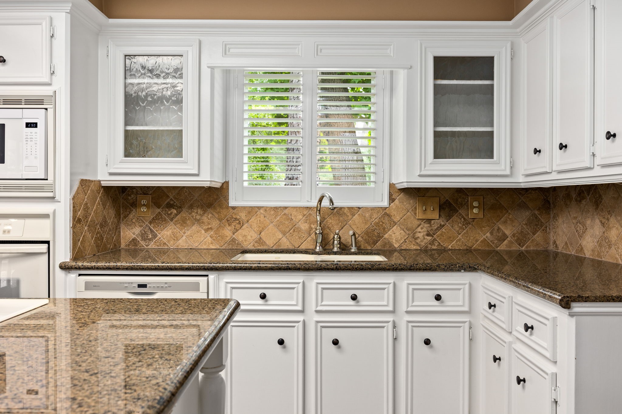 6623 Ampton Drive Spring, TX 77379 - Photo 17 of 45 Granite countertops, glass window cabinets, newer hardware, and plantation shutters are perfectly maintained.