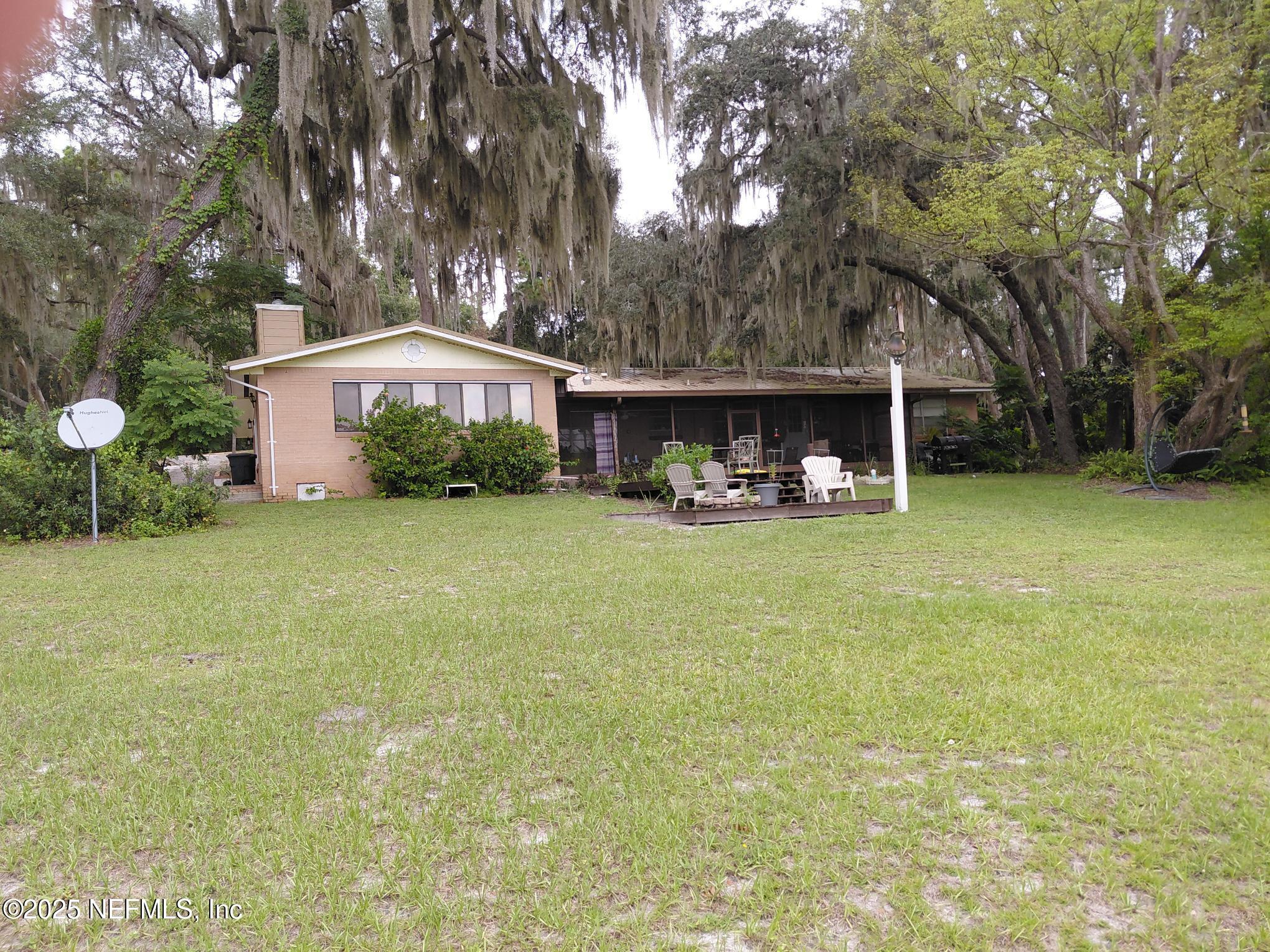 113 Lake Como Point Road Pomona Park, FL 32181 - Photo 11 of 36 a front view of house with yard and trees in the background