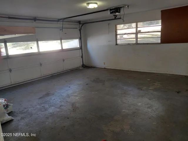 a view of a kitchen with refrigerator and white cabinets