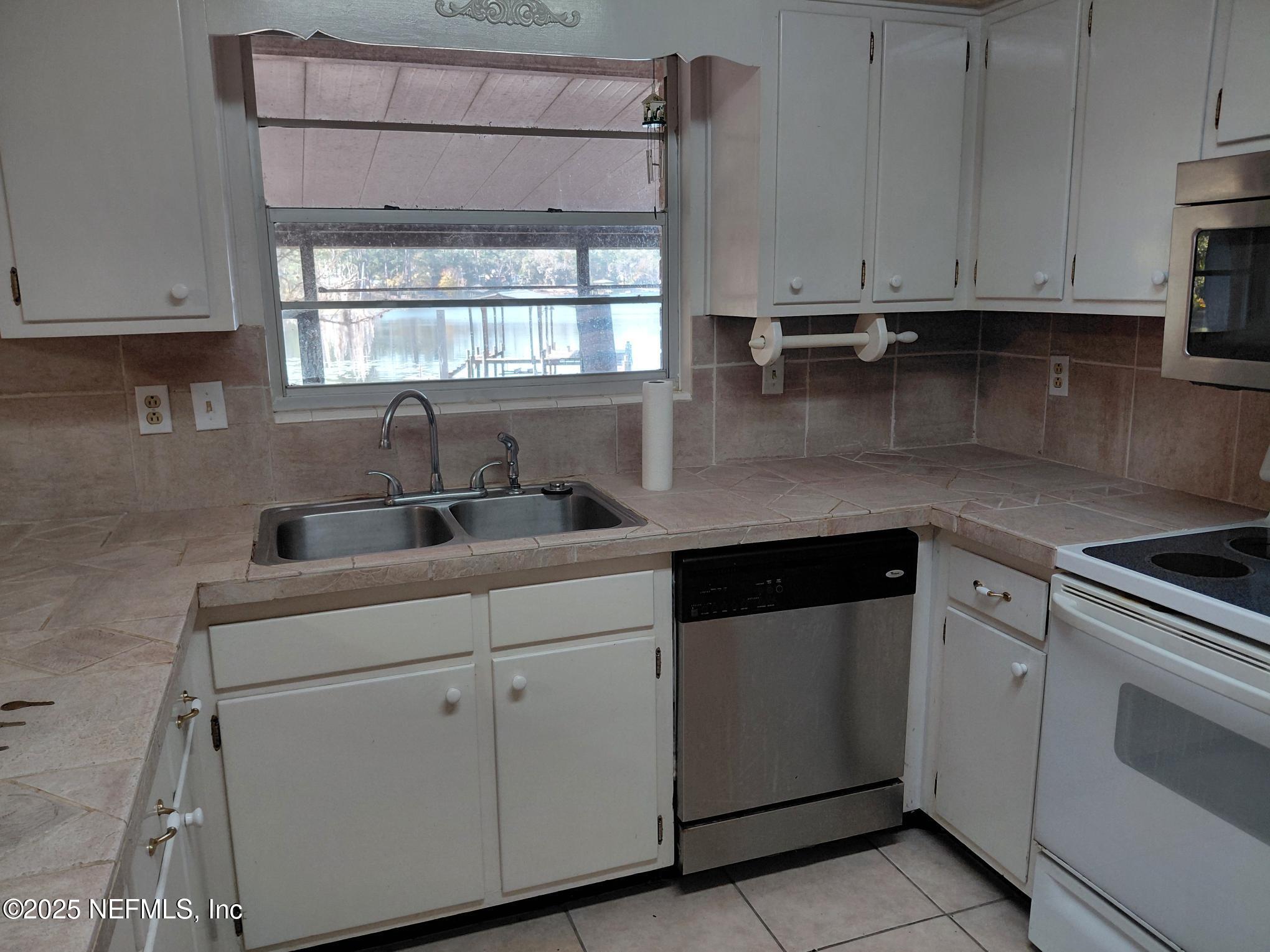 113 Lake Como Point Road Pomona Park, FL 32181 - Photo 27 of 36 a kitchen with appliances cabinets and a window