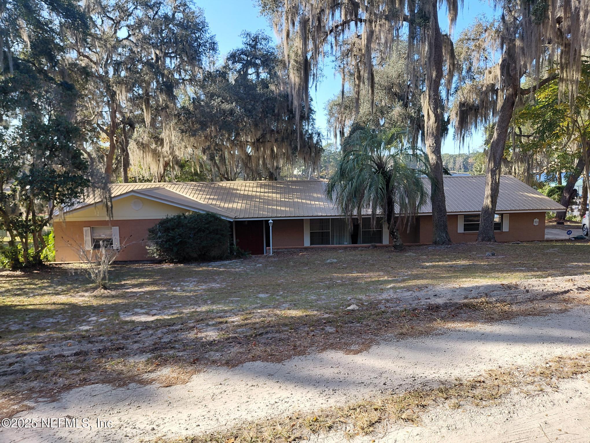 113 Lake Como Point Road Pomona Park, FL 32181 - Photo 4 of 36 a front view of a house with a yard and trees