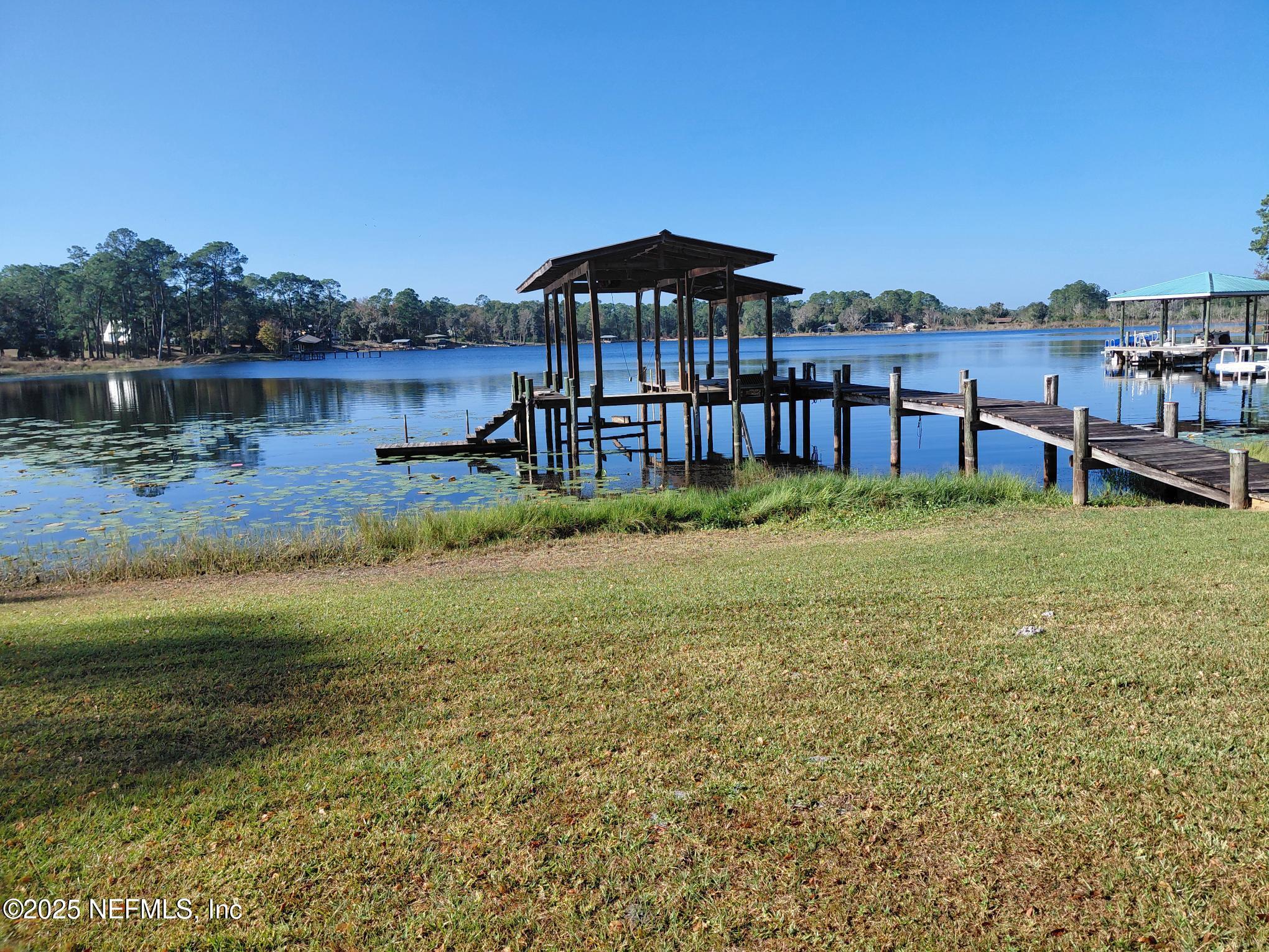 113 Lake Como Point Road Pomona Park, FL 32181 - Photo 5 of 36 a view of a lake with a yard and potted plants