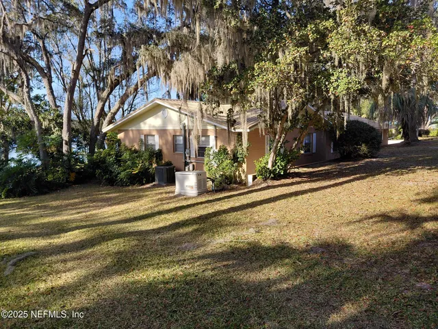 a view of a house with a yard and sitting area
