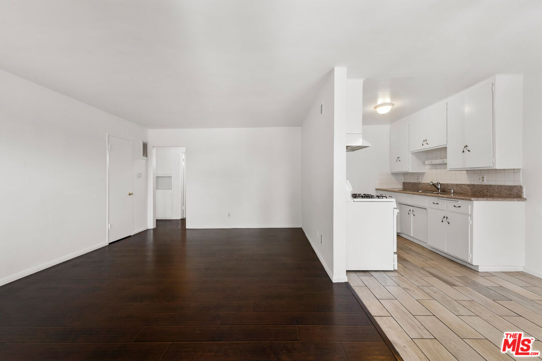 3355 South Canfield Avenue, Unit 11 Los Angeles, CA 90034 - Photo 1 of 23 a view of kitchen with granite countertop white cabinets and black appliances